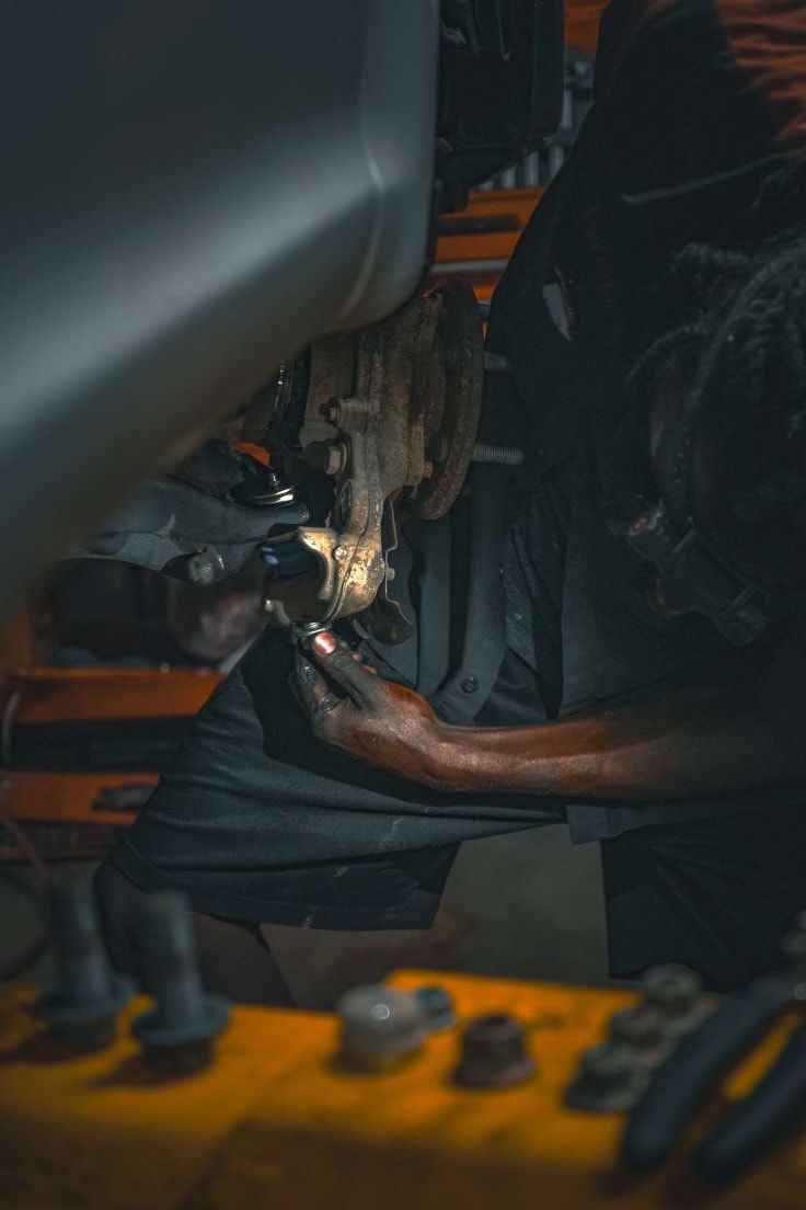 A man is working on a car in a garage.