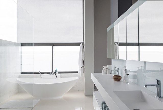 A bathroom with a tub , sink and mirror
