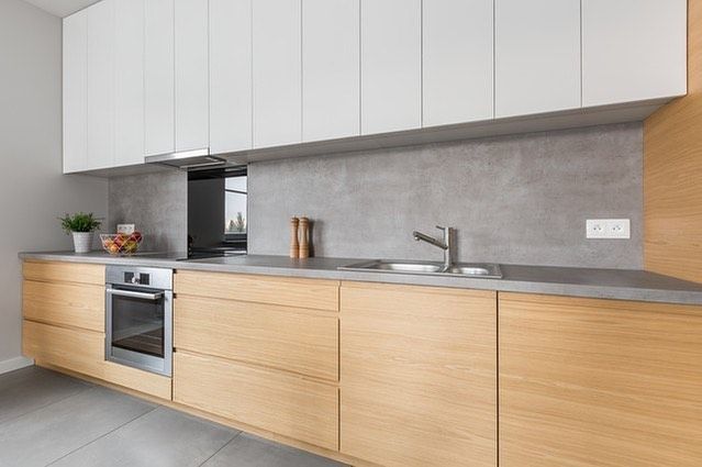 A kitchen with wooden cabinets , stainless steel appliances , a sink , and a stove.