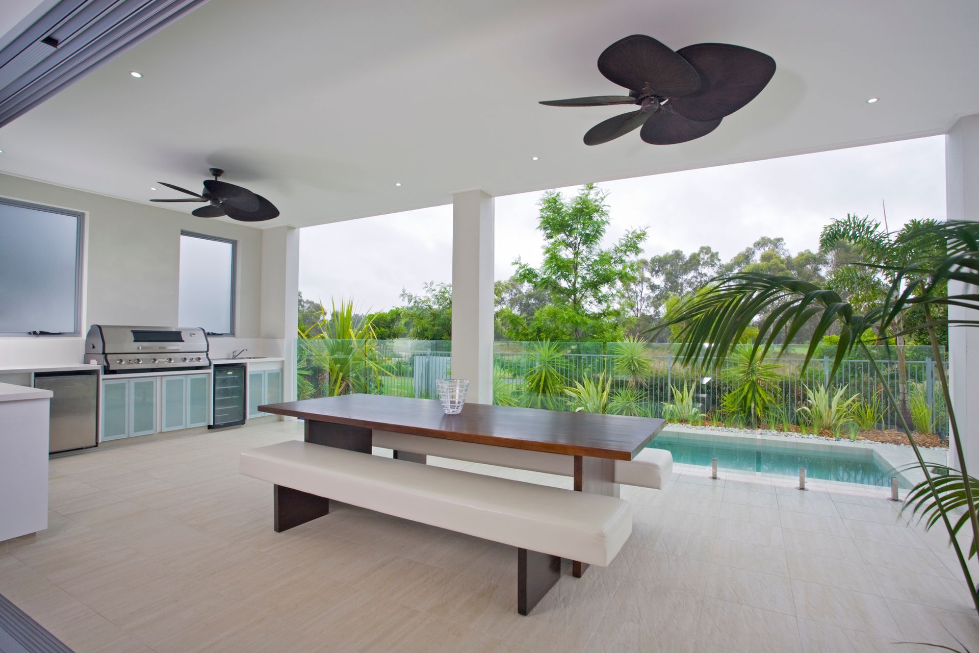 A kitchen with stools and a ceiling fan