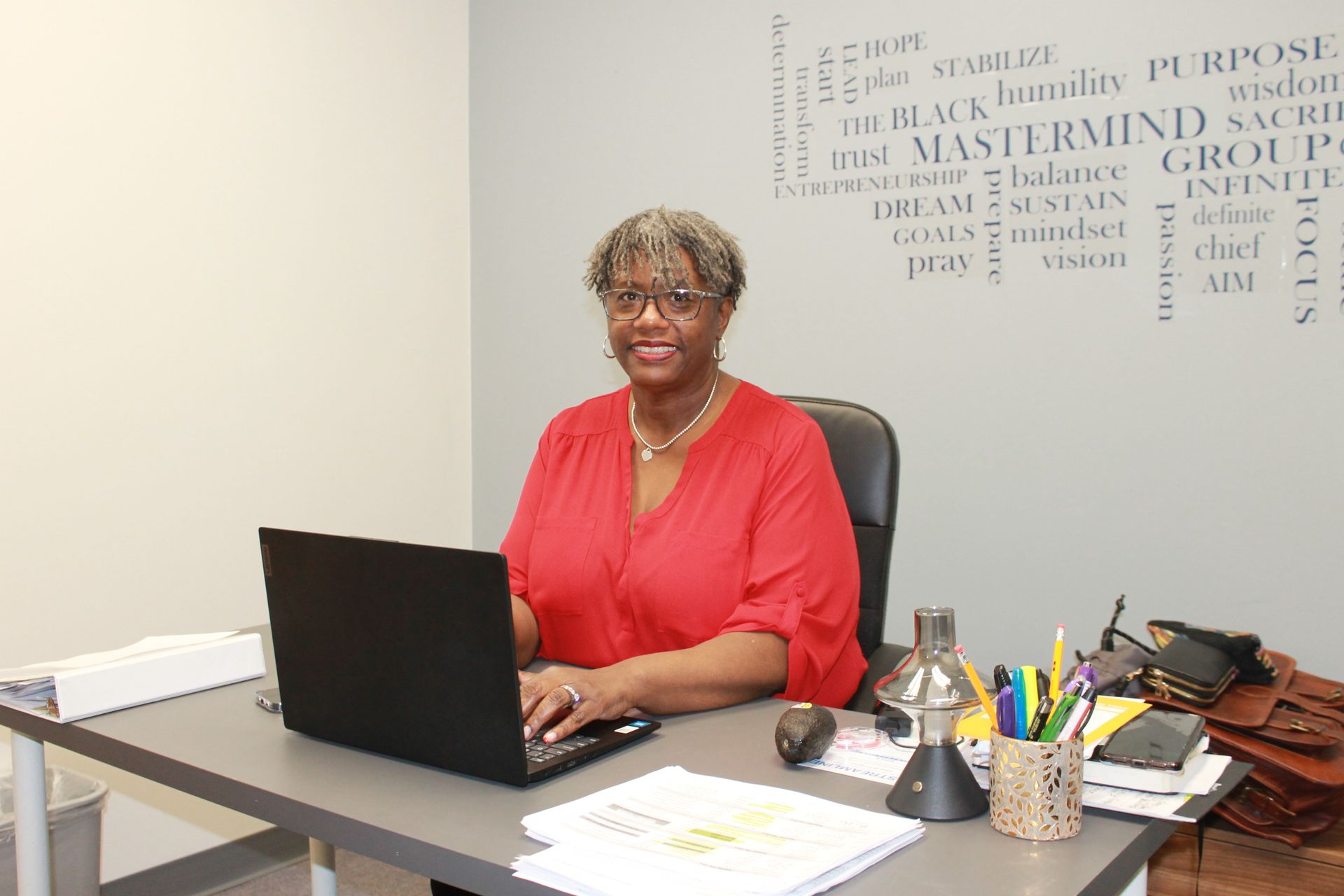 A woman is sitting at a desk with a laptop computer.