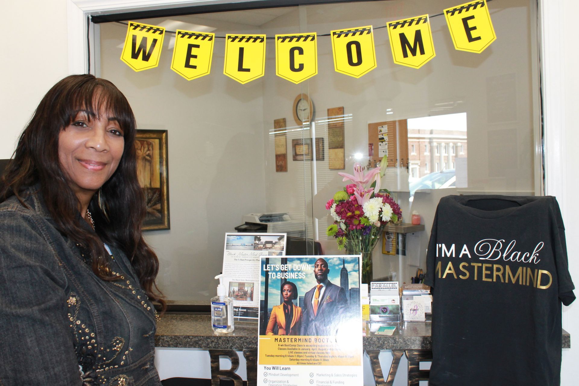 A woman is standing in front of a welcome sign
