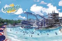 A picture of a water park with a lot of people swimming in it.