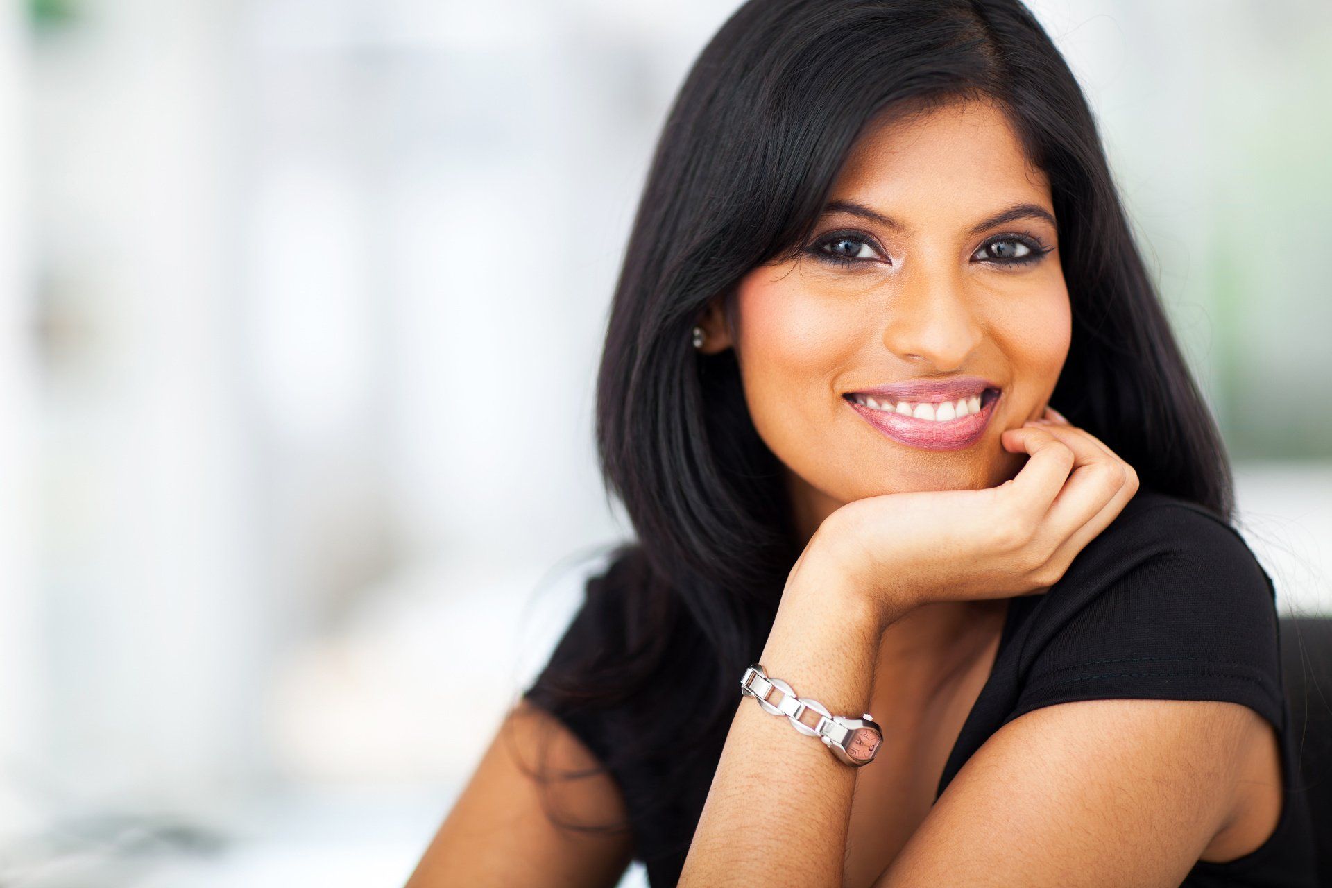 Woman smiling with head propped up with hand