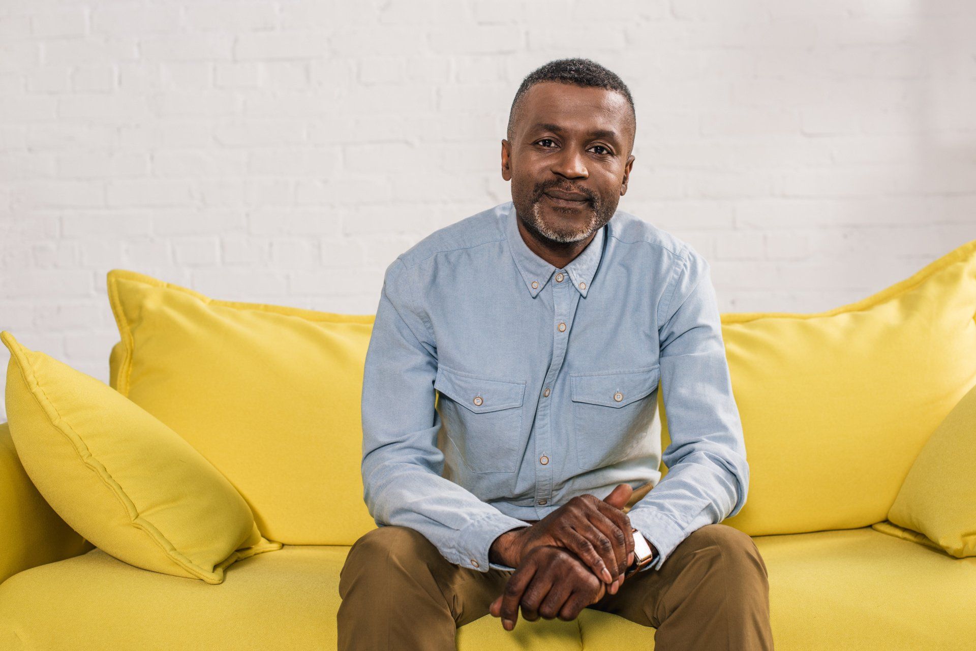Man sitting on yellow sofa