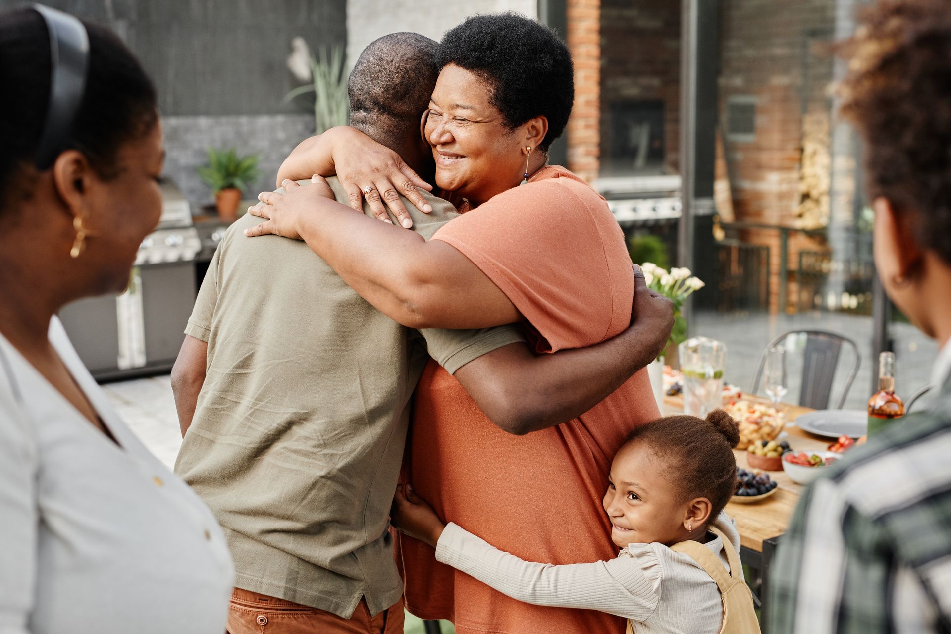 Woman embracing friend during family gathering.