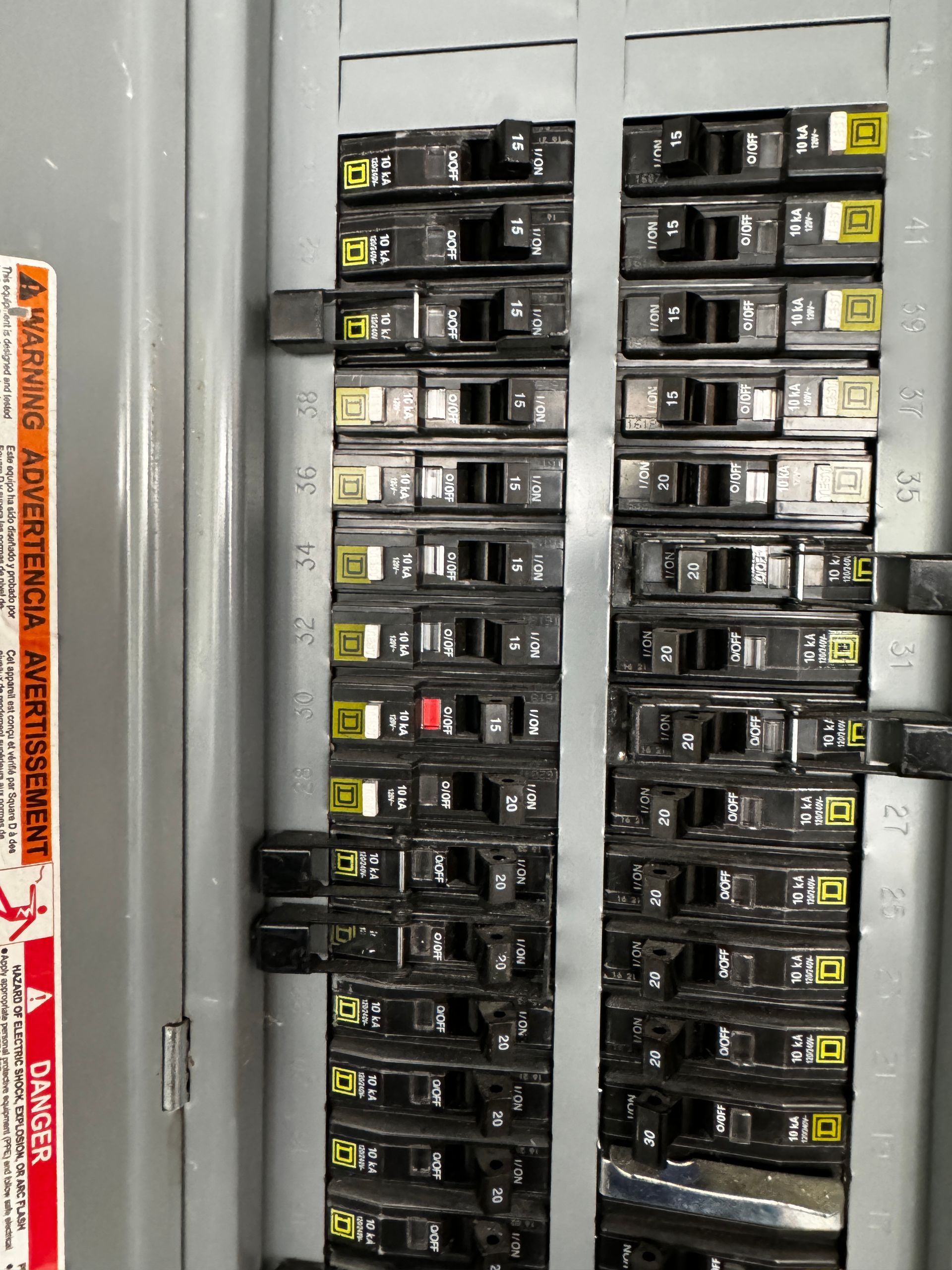A close up of a electrical panel with a warning sign on it