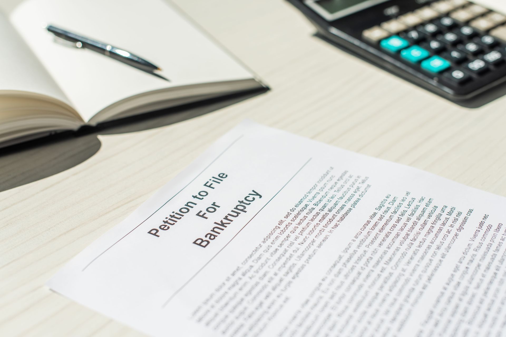 Open book and pen beside a printed employment rights document on a desk with a calculator.