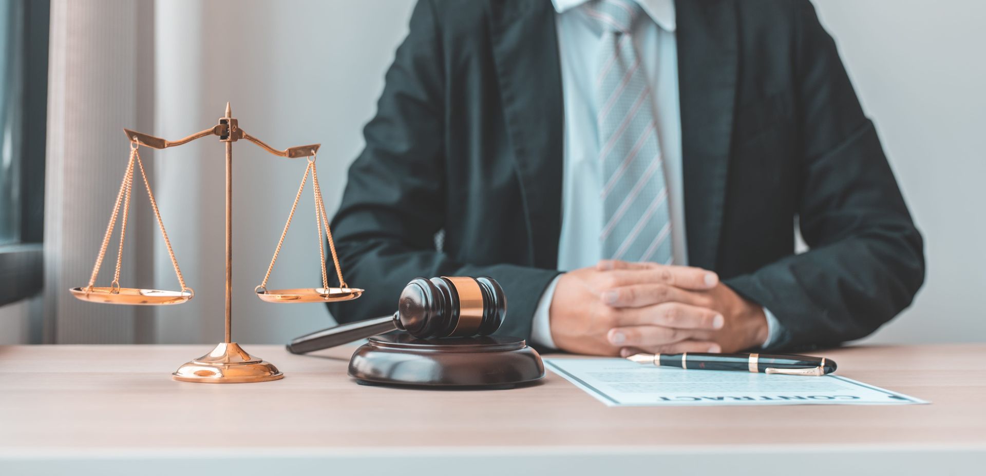 Lawyer at desk with gavel, scales of justice, and documents in an office