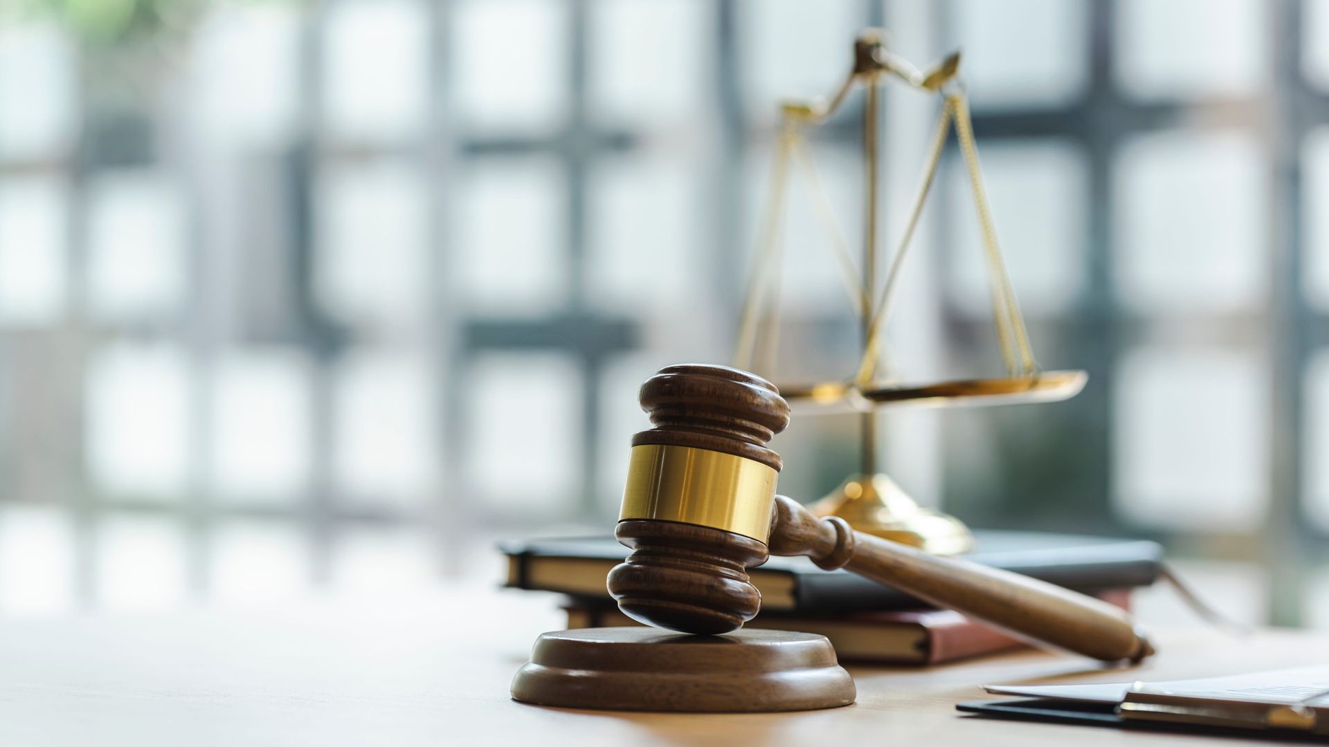 Lawyer’s desk with gavel, scales of justice, and documents in a courtroom-style setting