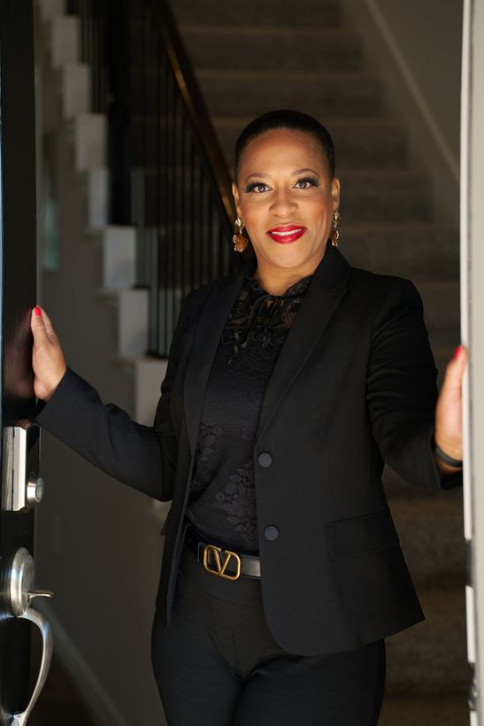 A woman standing at the opening of a door.
