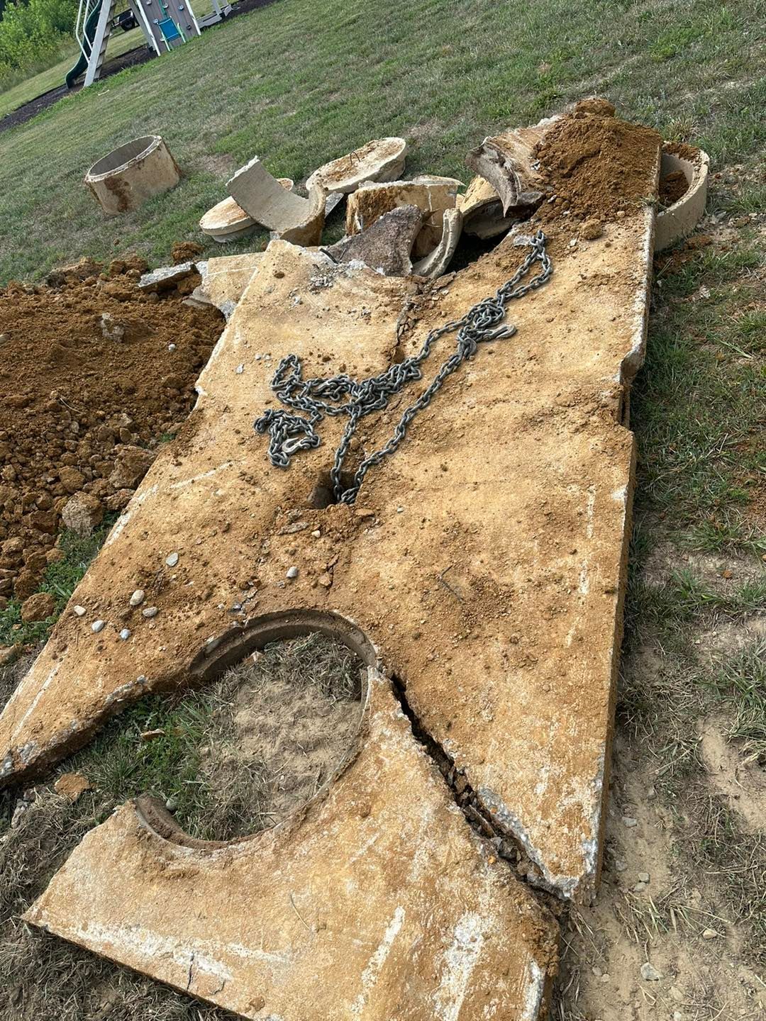 cracked and broken top of the septic tank because a truck drove over it.