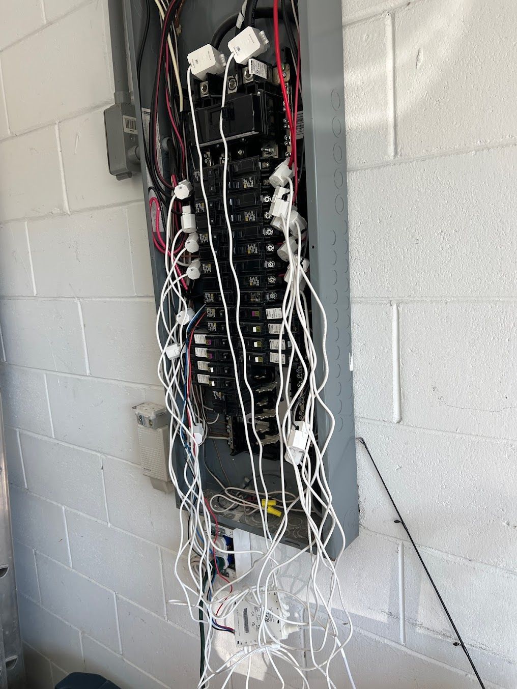 a very messy electrical box is hanging on a brick wall