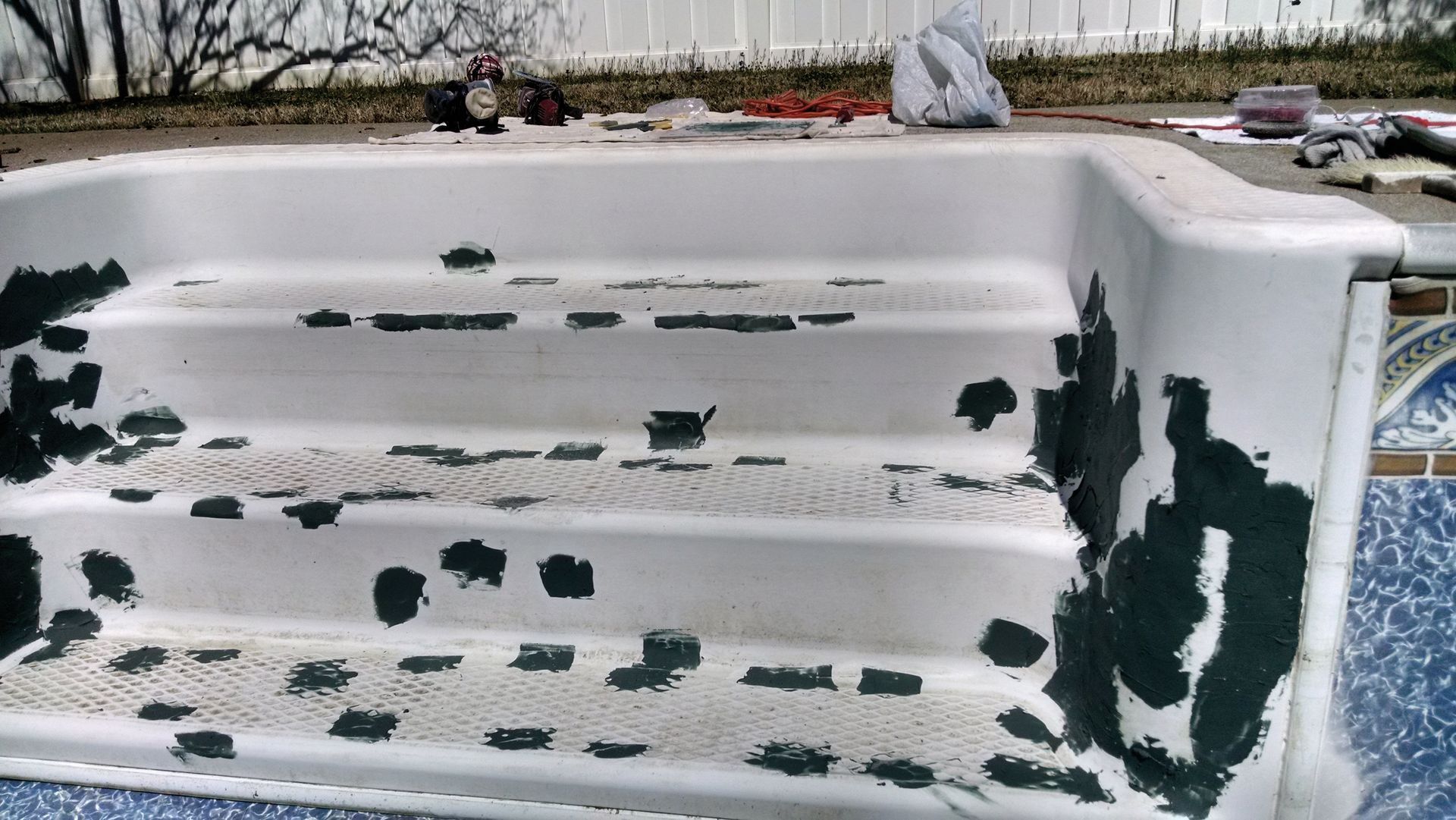 a white bathtub with black paint on the steps