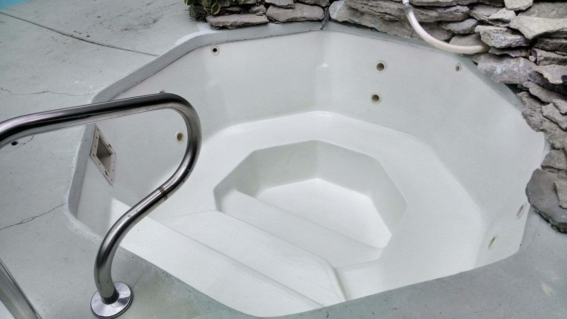 a white hot tub with stairs leading up to it