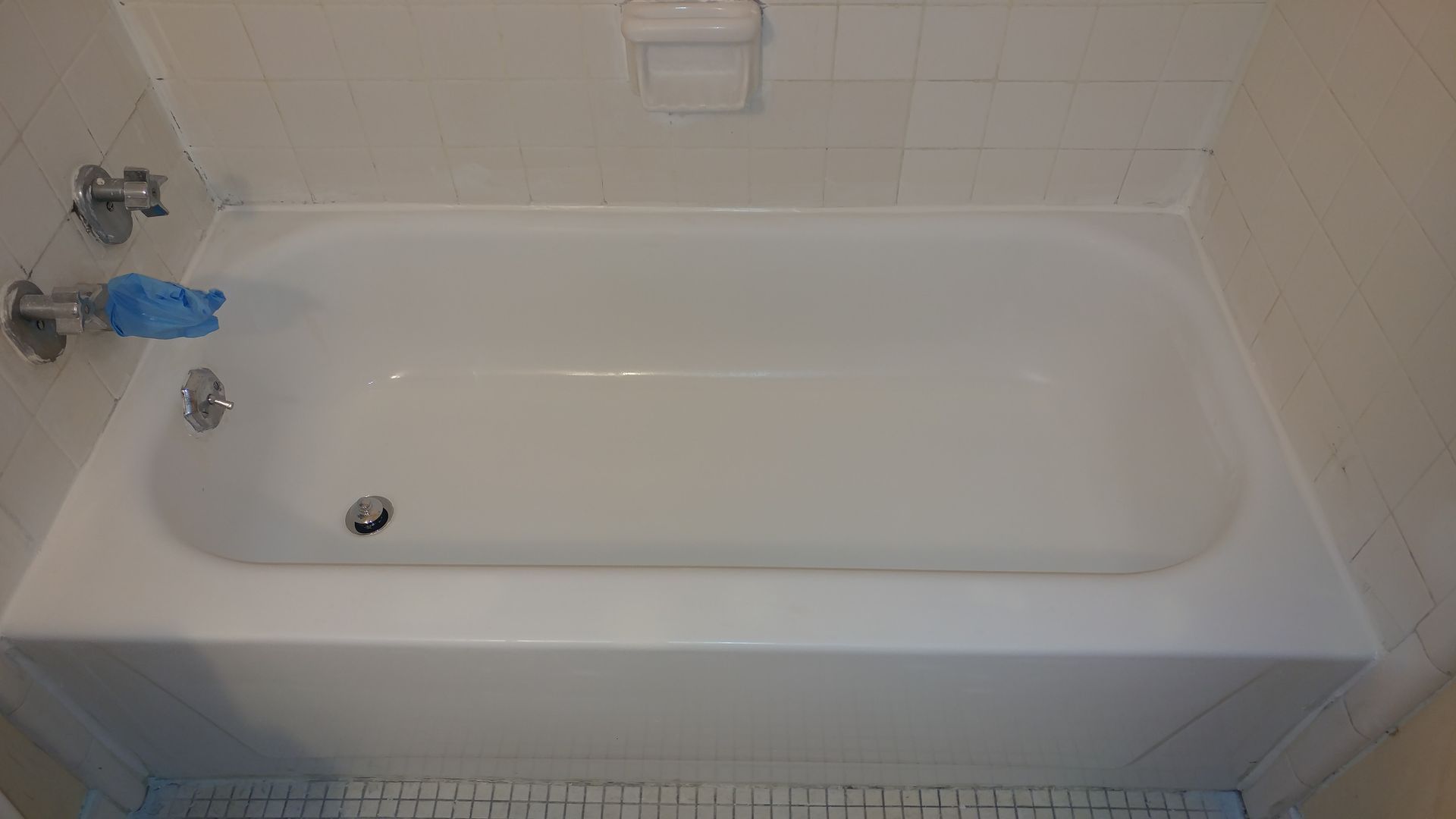 a white bathtub is sitting in a bathroom next to a tiled floor .
