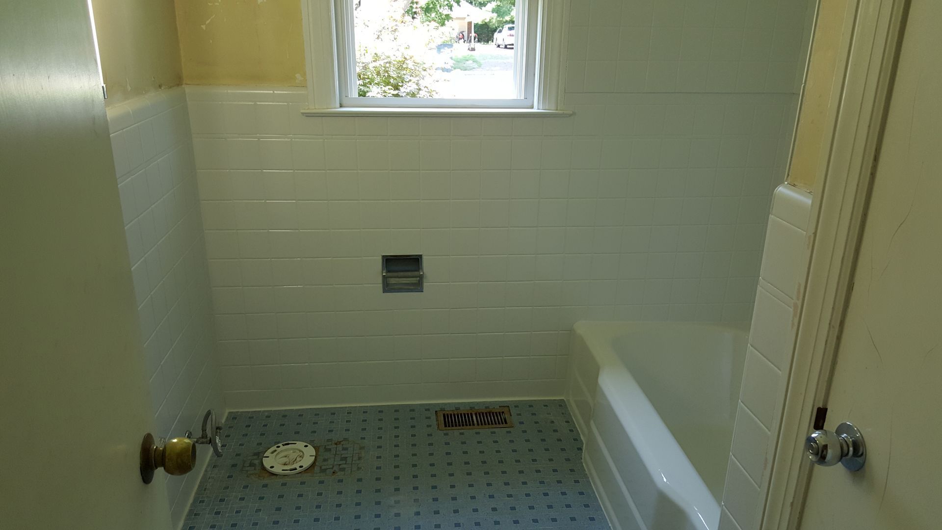 a bathroom with a bathtub and a window .