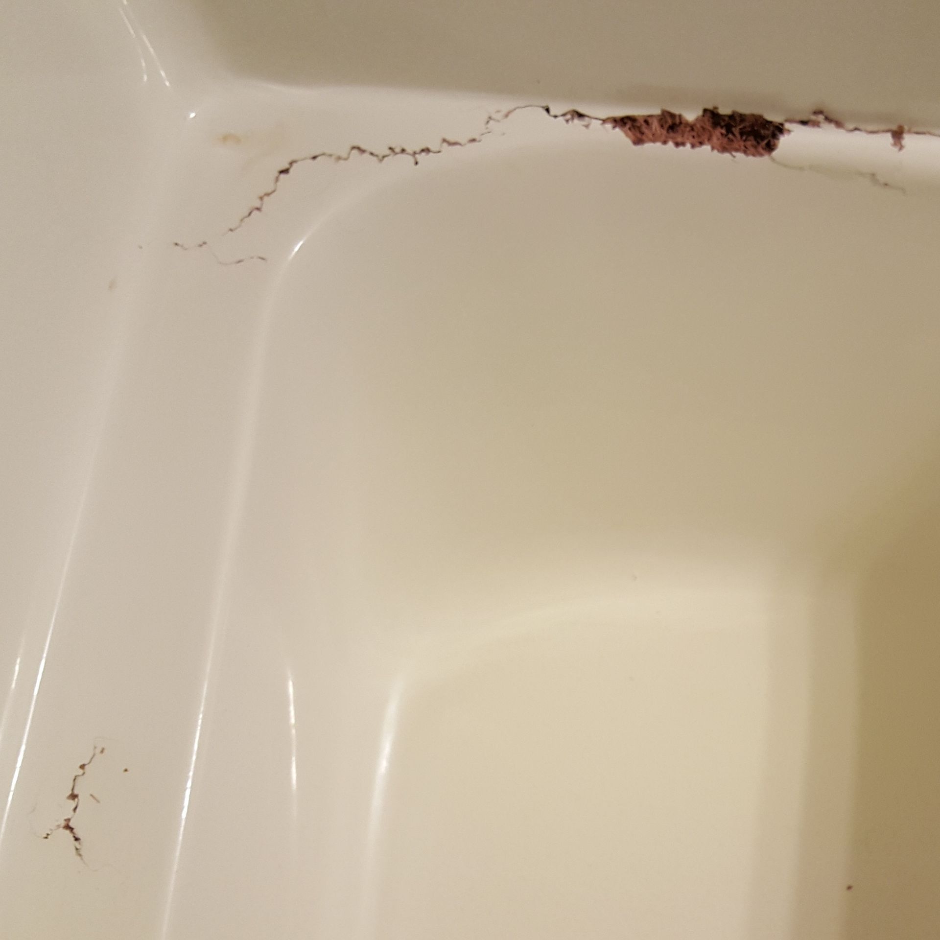 a close up of a bathroom sink with a crack in it .