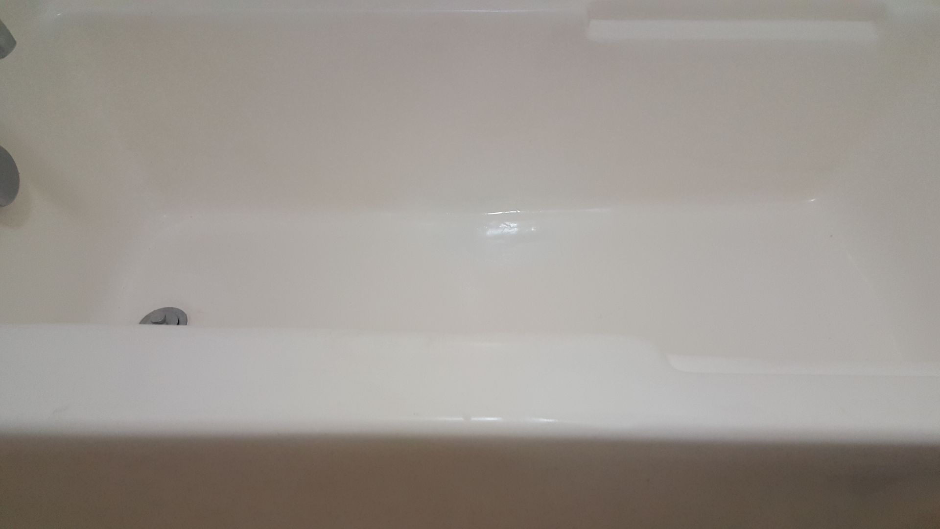 a white bathtub is sitting in a bathroom next to a wall .