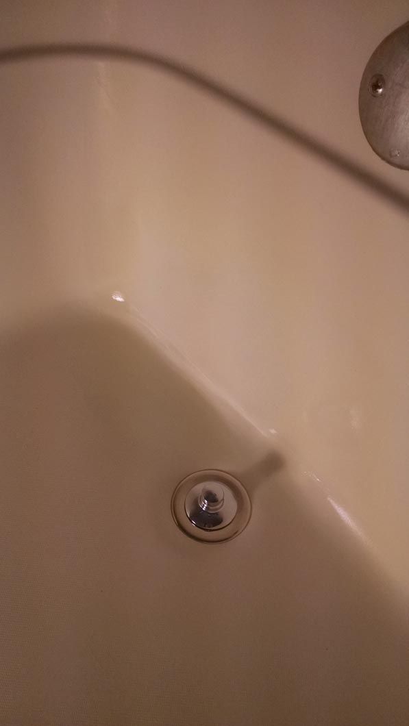 a close up of a white bathtub with water in it .