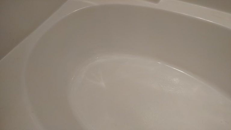 a close up of a white bathtub with water in it .