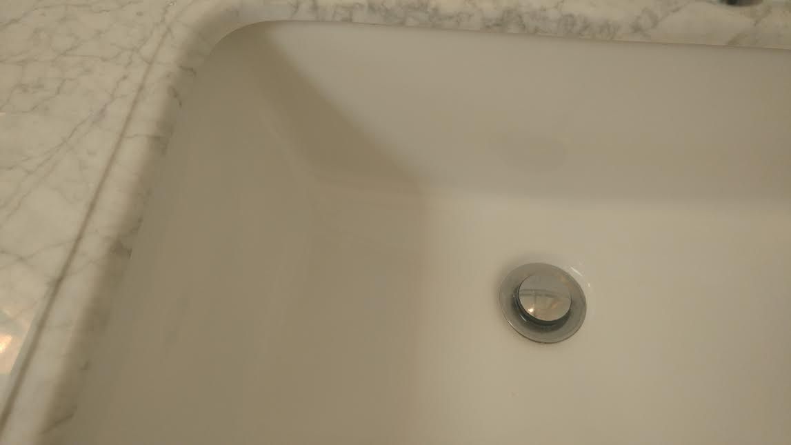 a close up of a bathroom sink with a drain .