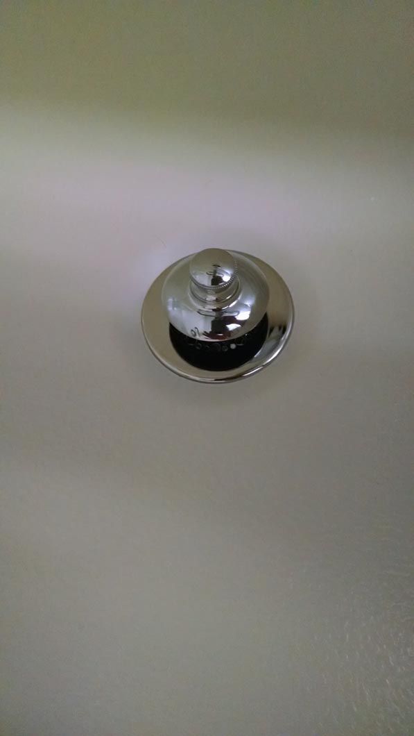 a close up of a sink drain on a white surface .