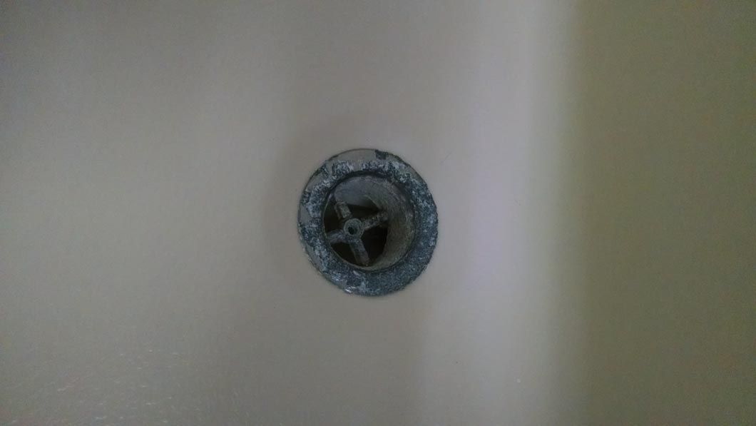 a close up of a drain hole in a bathroom sink .
