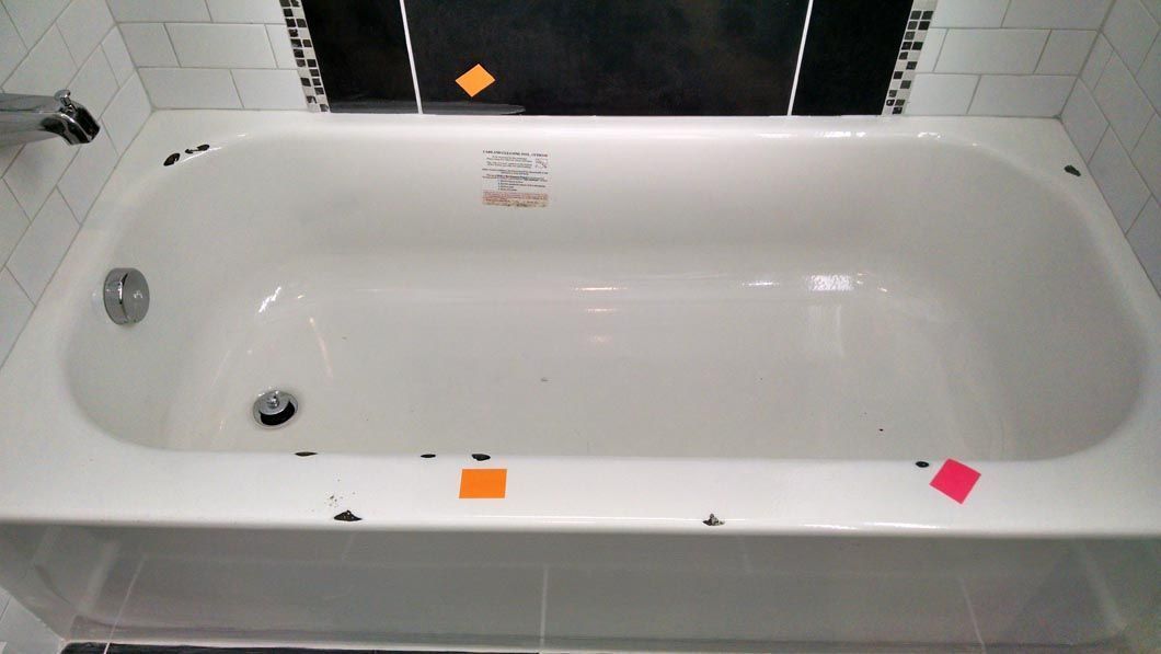 a white bathtub in a bathroom with stickers on it .