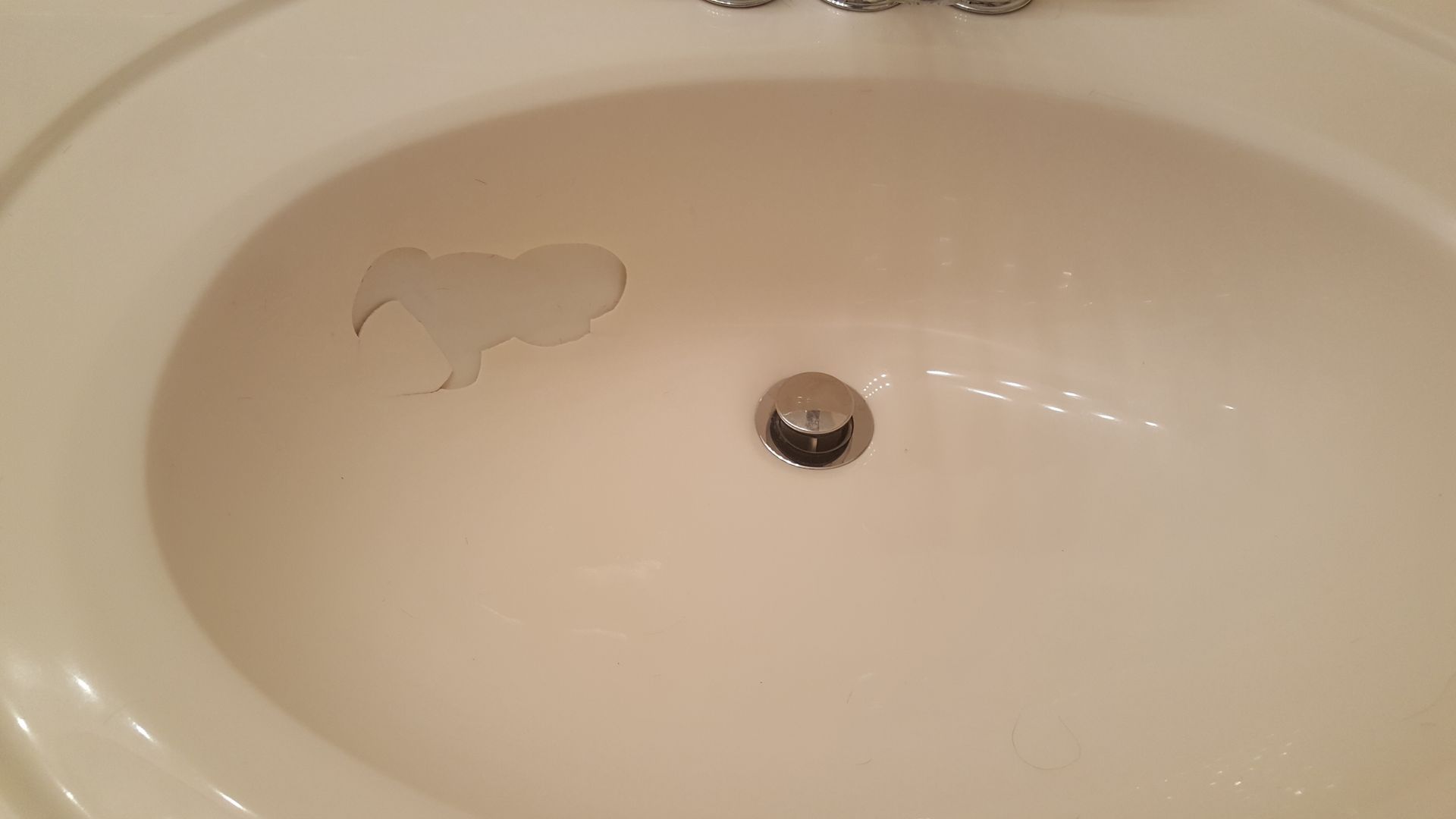 a close up of a bathroom sink with a hole in it .