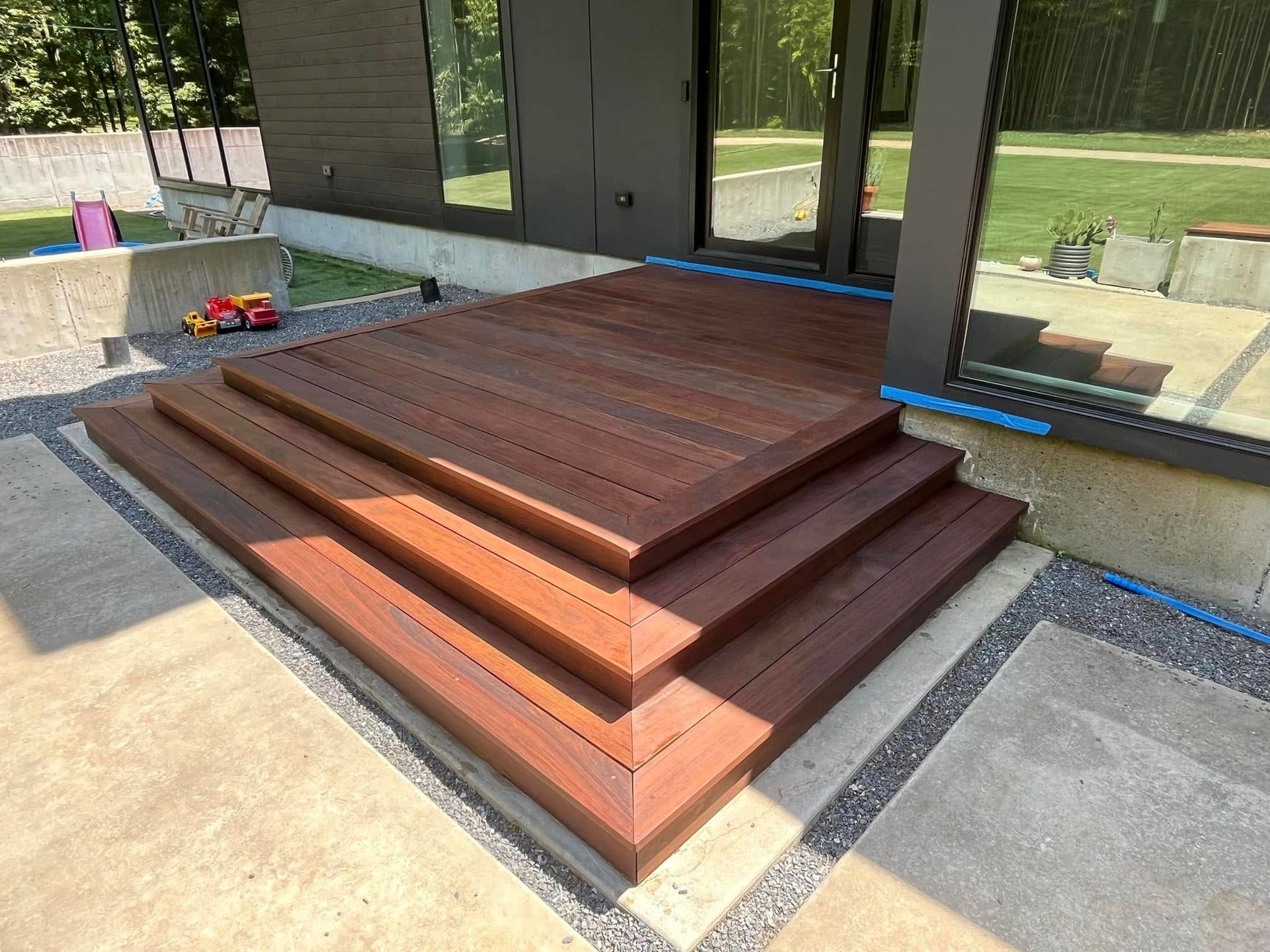 Wooden deck, reddish-brown planks arranged in parallel lines.