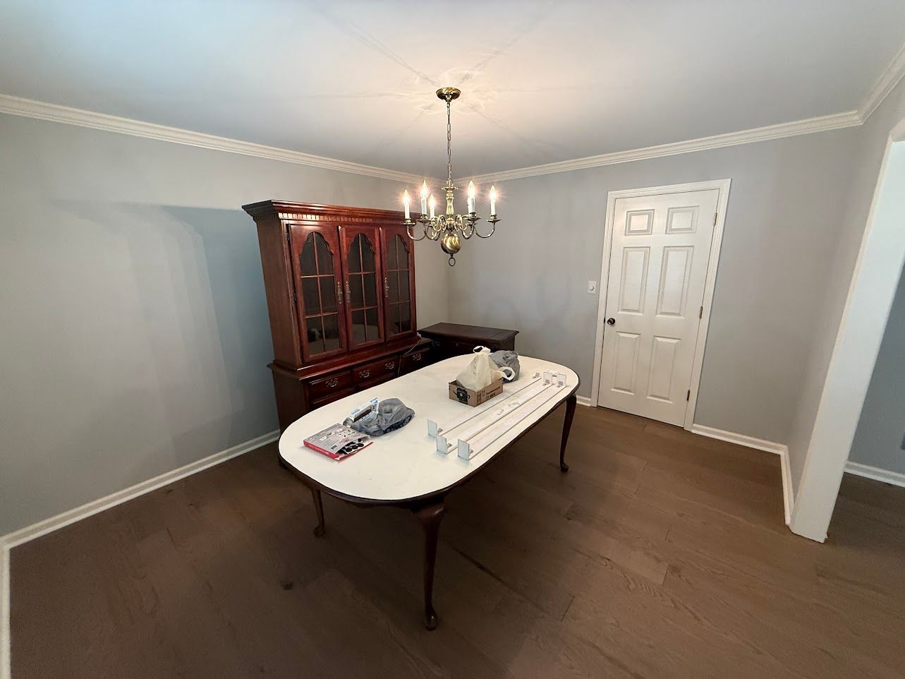 Mustard yellow armchair with pillows, bookcase, and plants in a minimalist living room.