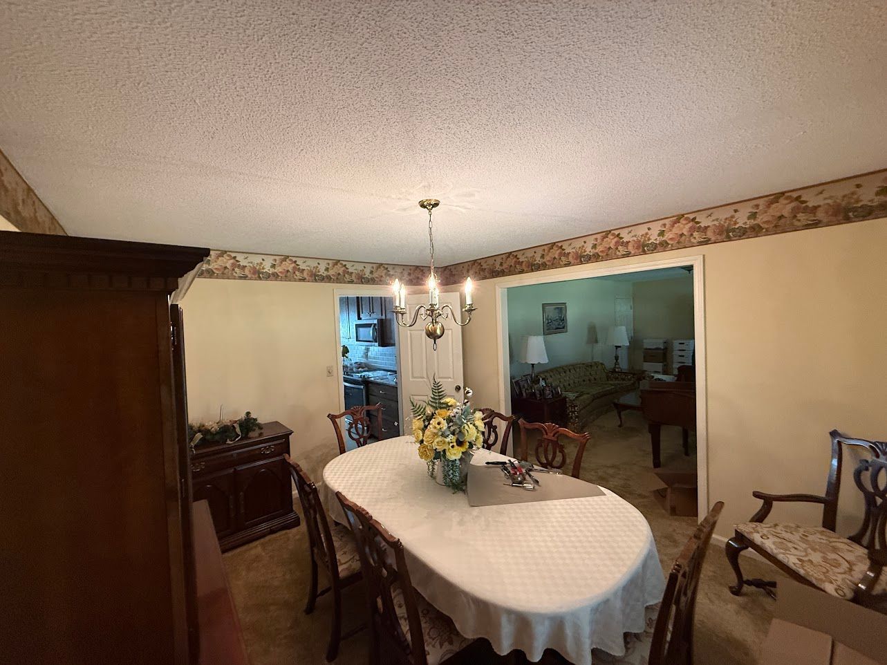 Bathroom with sink, mirror, and light fixture. Cream-colored walls, white vanity, and silver fixtures.
