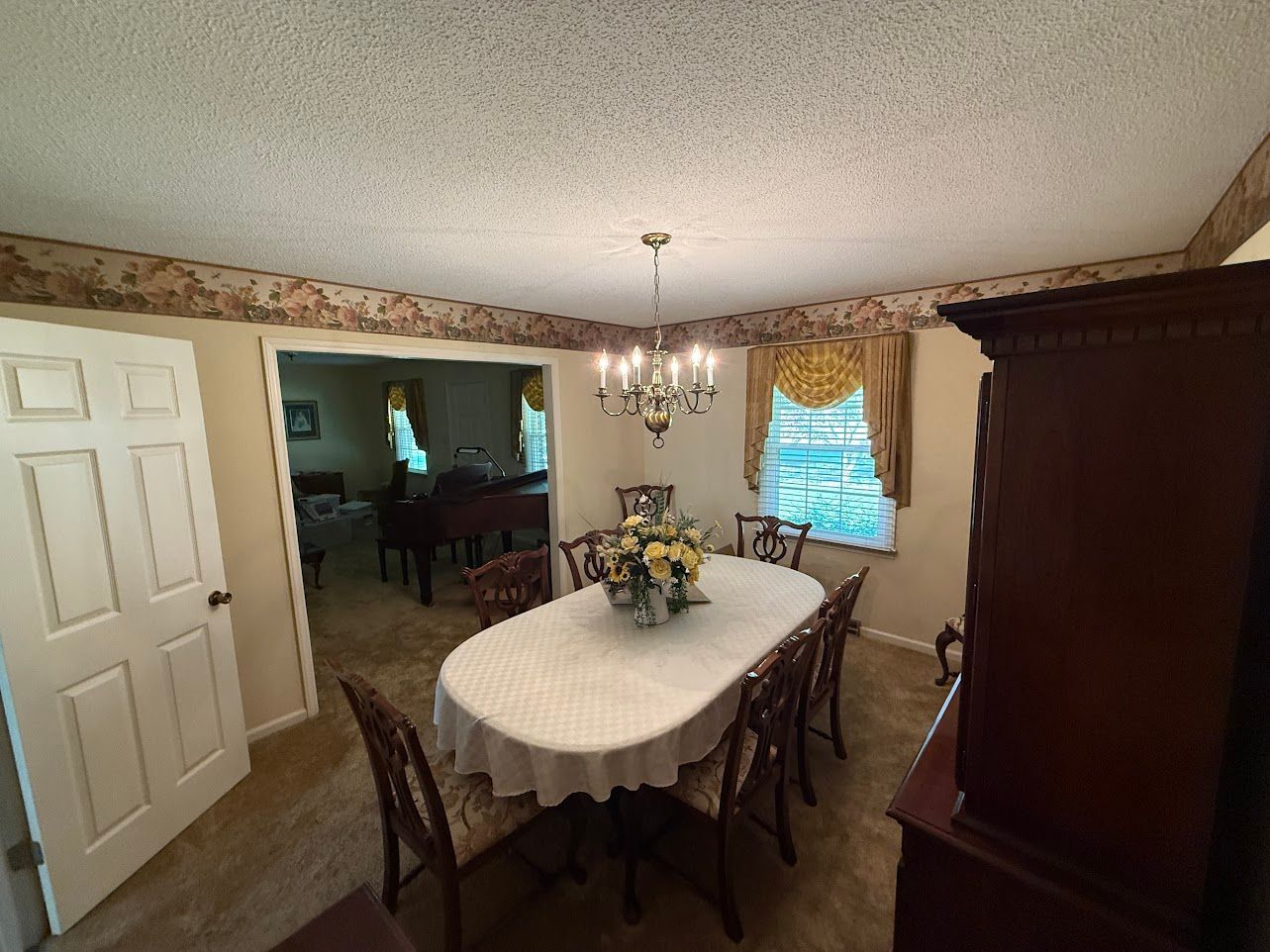 Bathroom with sink, mirror, and light fixture. Cream-colored walls, white vanity, and silver fixtures.