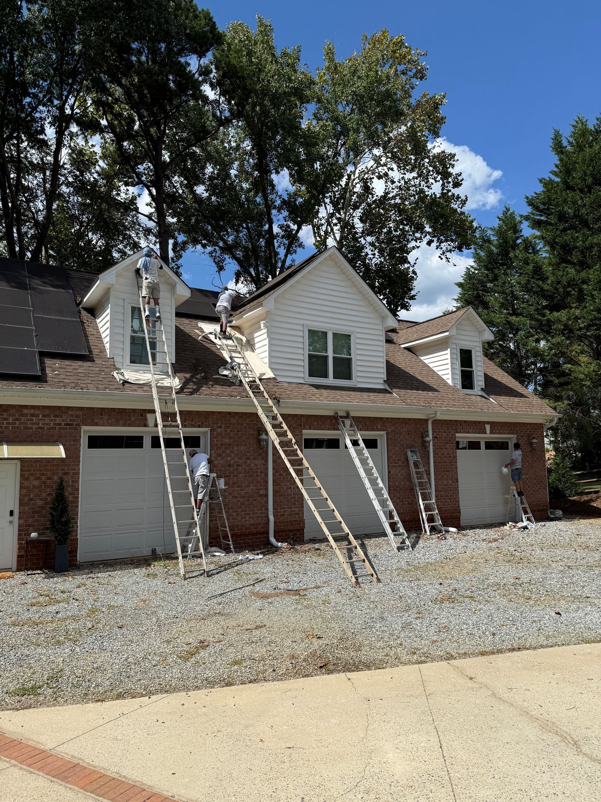 Modern office: desk with laptop, brown leather chair, Eames chair, shelving, and large windows.