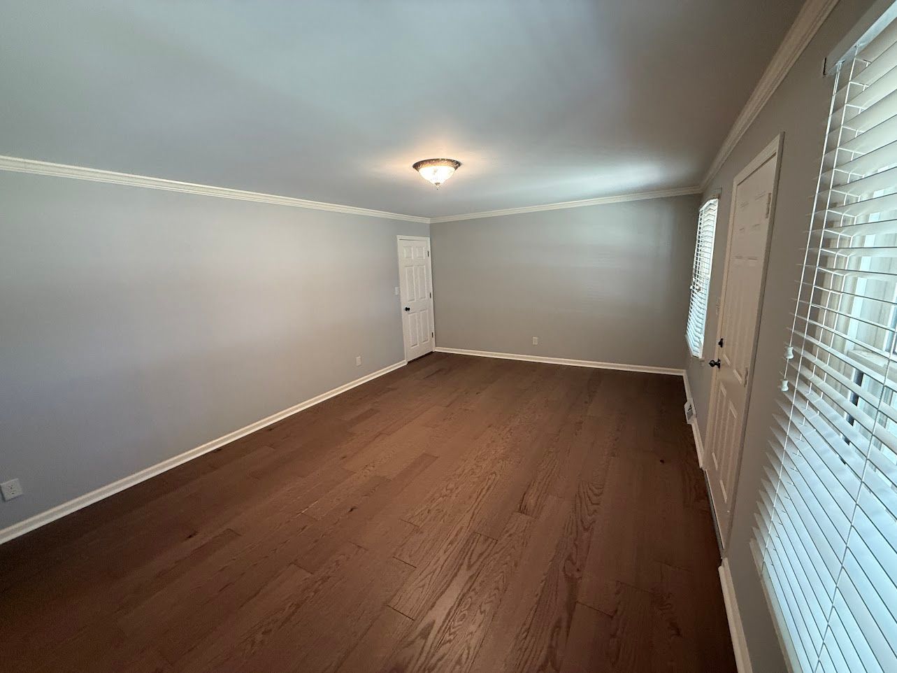 Wooden staircase with white risers and brown treads, wooden handrail, leading upward.