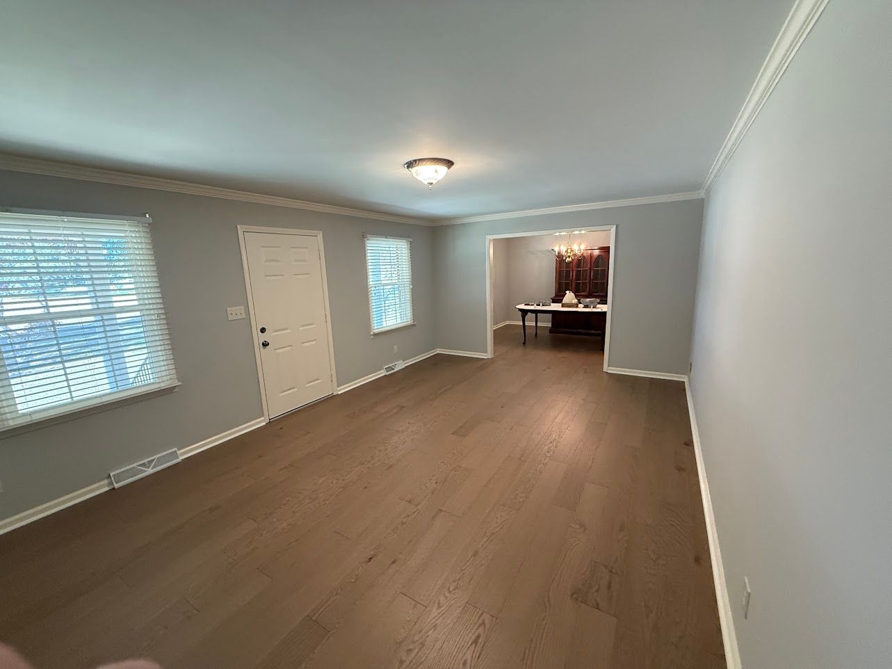 Wooden staircase with white risers and brown treads, wooden handrail, leading upward.