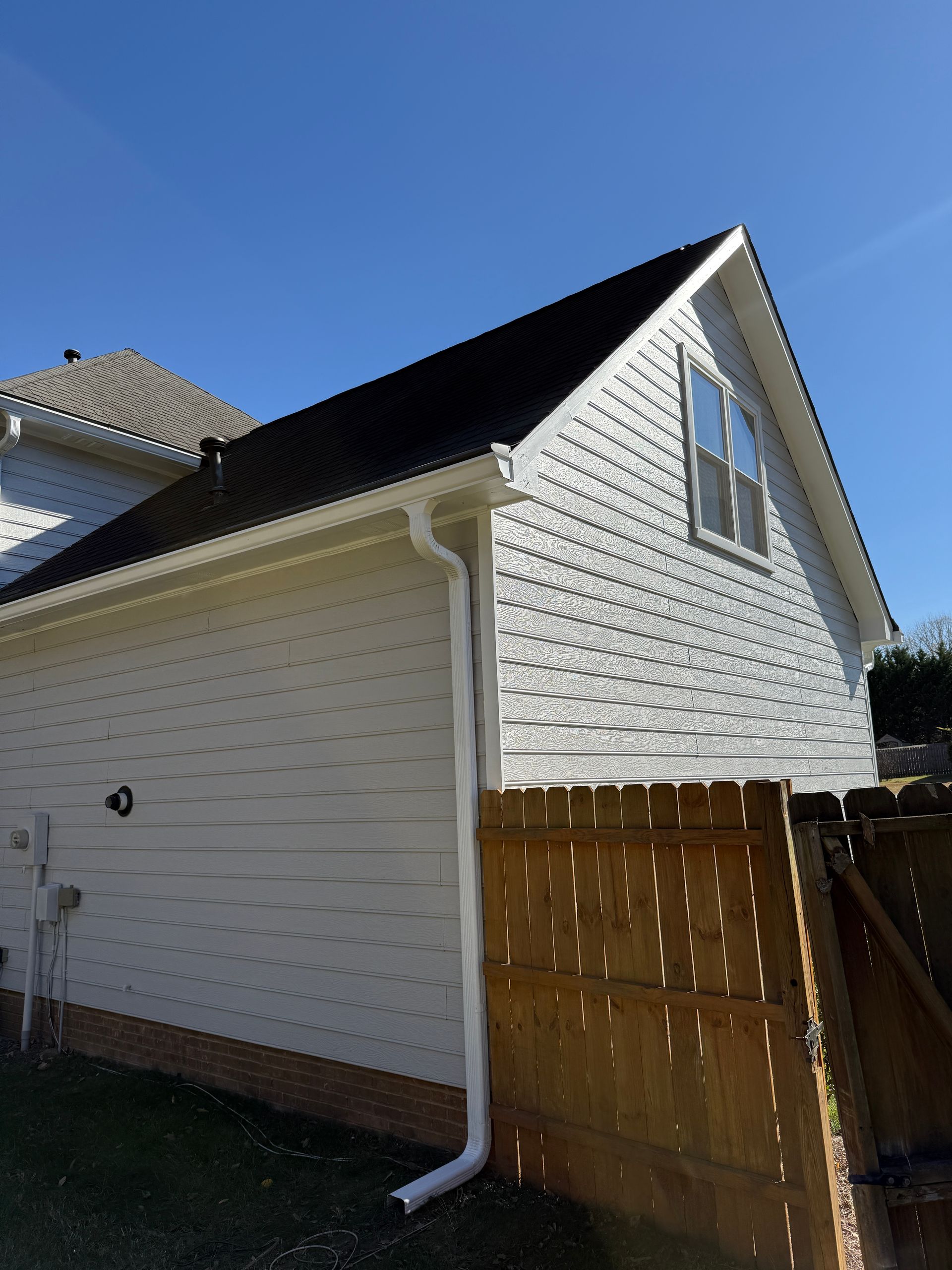 Bright hospital room with a bed, sofa, large windows, and medical equipment.