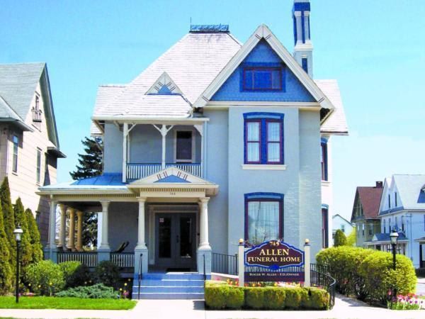 Allen Funeral Home, blue Victorian-style building with sign in front.
