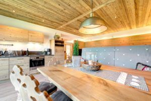 Ein Holztisch und Stühle in einer Küche mit Holzdecke.