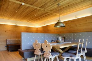 Ein Esszimmer aus Holz mit Tisch und Stühlen.