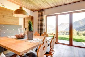 Ein Esszimmer mit einem Holztisch und Stühlen und einem großen Fenster.