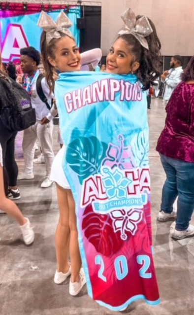 Two cheerleaders are holding a banner that says champions