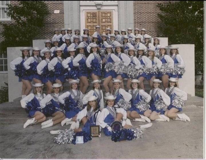 A group of cheerleaders are posing for a picture