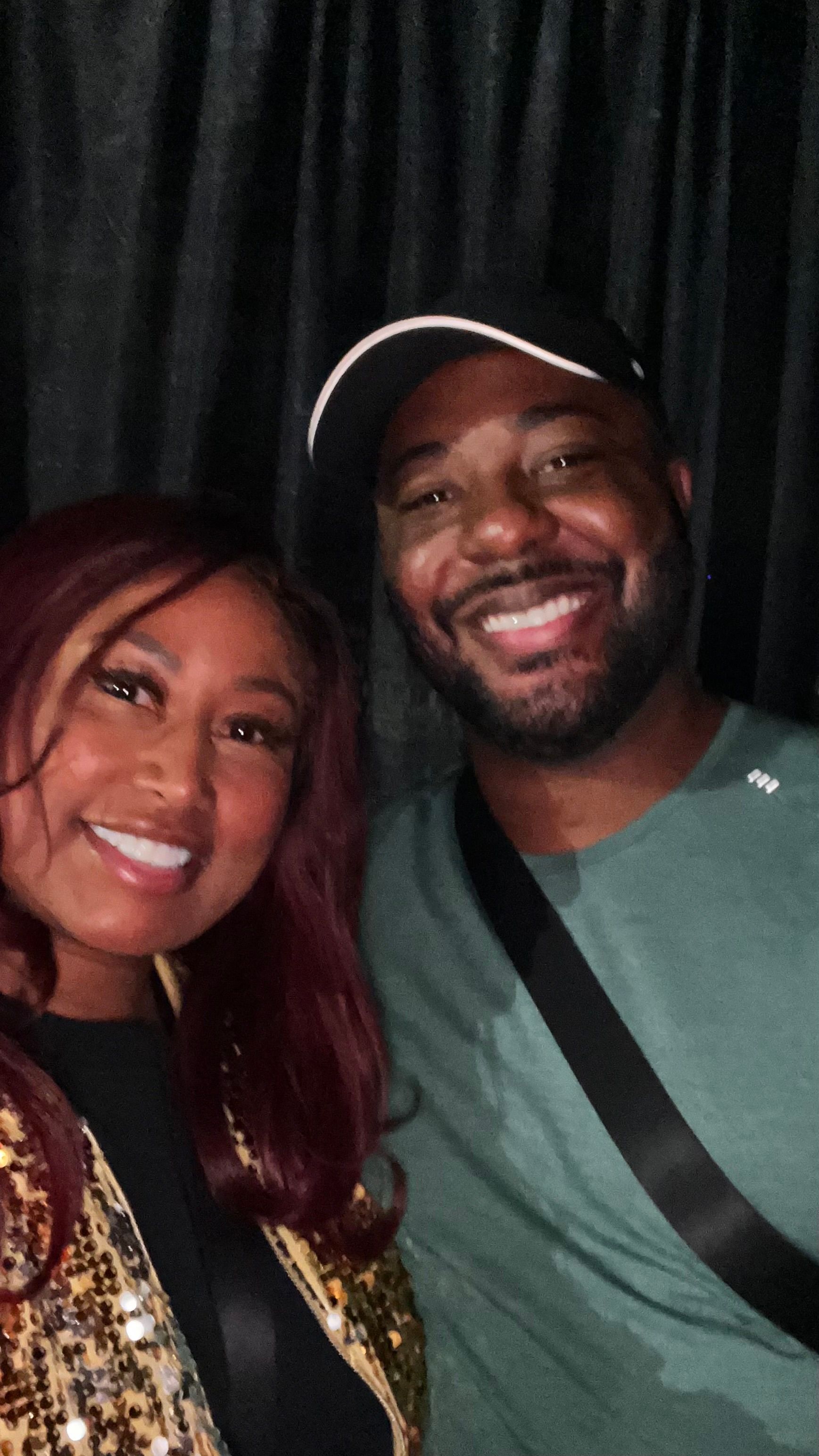 A man and a woman are posing for a picture and smiling for the camera.