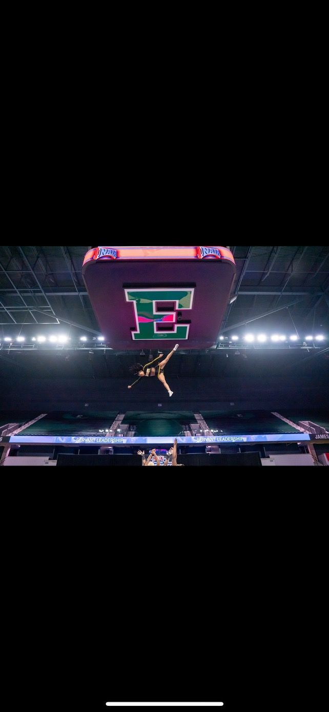 A basketball player is jumping in the air in a basketball stadium.