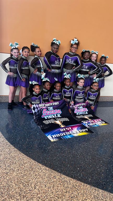 A group of cheerleaders are posing for a picture.