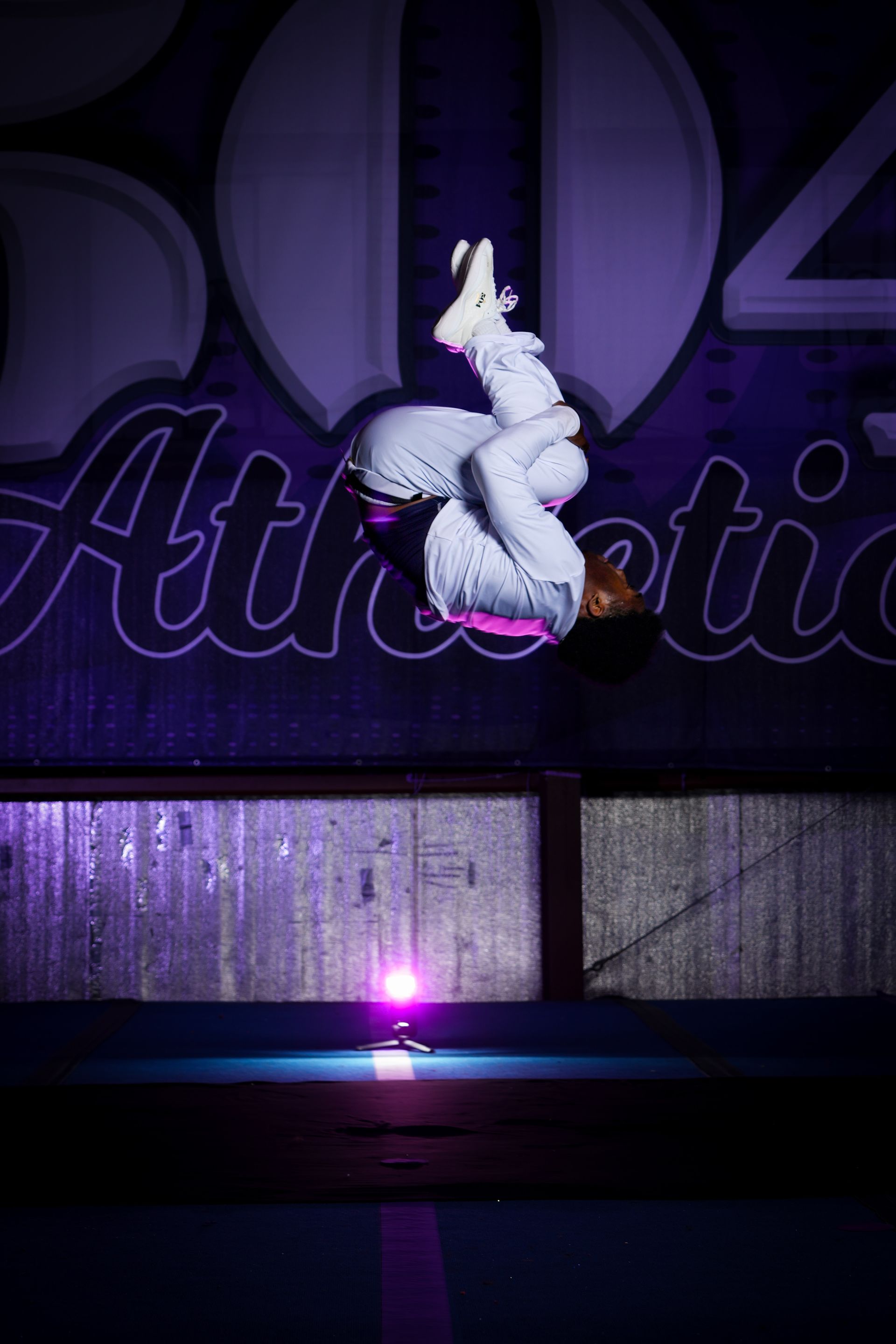 A person is doing a handstand on a trampoline.