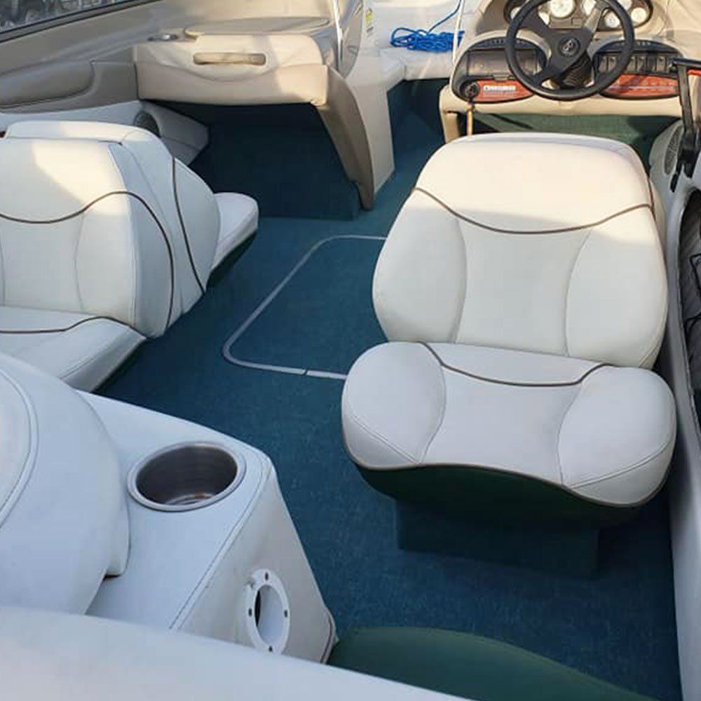 the inside of a boat with white seats and a steering wheel