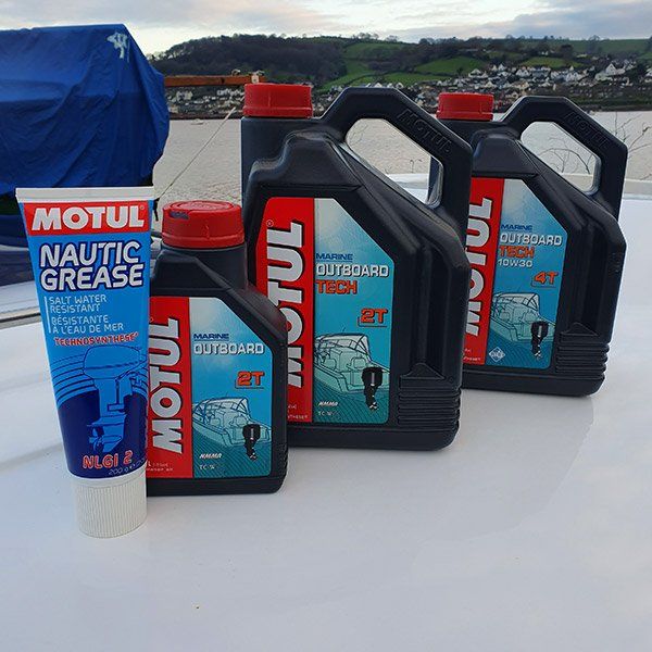 several bottles of motul nautica grease are lined up on a table